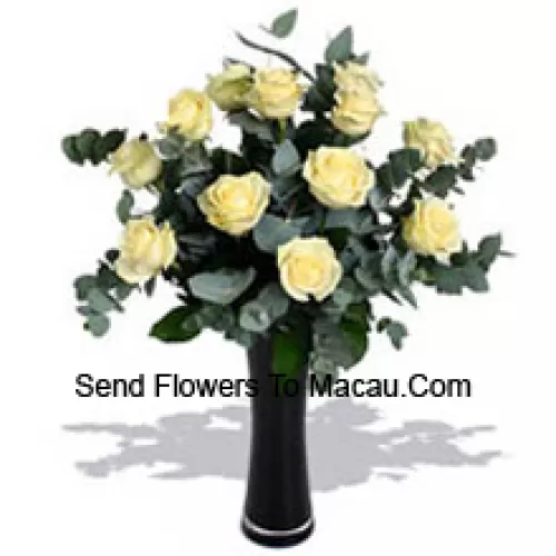 11 roses blanches avec quelques fougères dans un vase