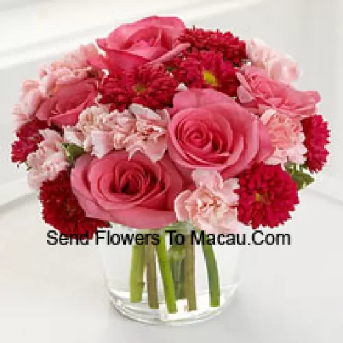 7 roses roses, 10 marguerites rouges et 10 oeillets roses dans un vase en verre