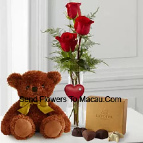 Trois roses rouges avec des fougères dans un vase, un mignon ours en peluche brun de 10 pouces et une boîte de chocolats Godiva. (Nous nous réservons le droit de substituer les chocolats Godiva par des chocolats de valeur égale en cas de non disponibilité. Stock limité)